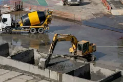 Concrete mixer truck arriving, next to the excavator.