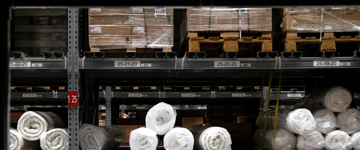 Warehouse rack with pallets and, on the beam, the labels for positions 25-22-20 to 25-19-20.